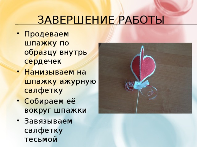 Завершение работы Продеваем шпажку по образцу внутрь сердечек Нанизываем на шпажку ажурную салфетку Собираем её вокруг шпажки Завязываем салфетку тесьмой 