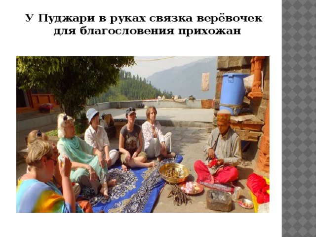 У Пуджари в руках связка верёвочек для благословения прихожан