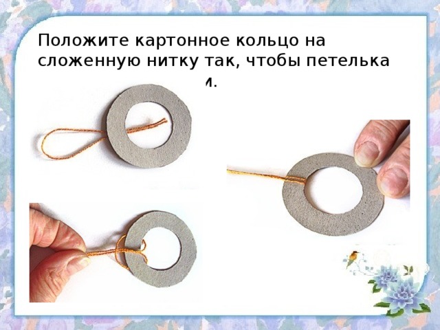 Положите картонное кольцо на сложенную нитку так, чтобы петелька оказалась снаружи.   