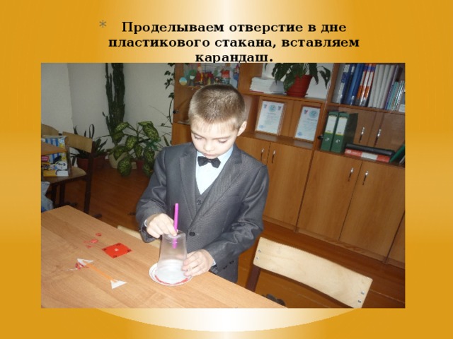 Проделываем отверстие в дне пластикового стакана, вставляем карандаш. 