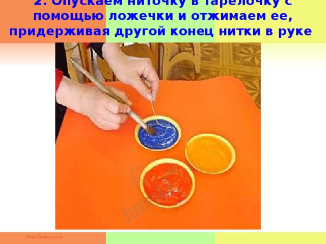 2. Опускаем ниточку в тарелочку с помощью ложечки и отжимаем ее, придерживая другой конец нитки в руке     