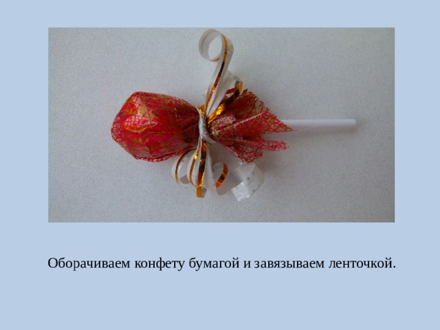 Оборачиваем конфету бумагой и завязываем ленточкой. 