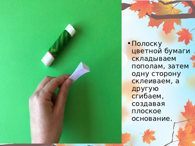Полоску цветной бумаги складываем пополам, затем одну сторону склеиваем, а другую сгибаем, создавая плоское основание.  