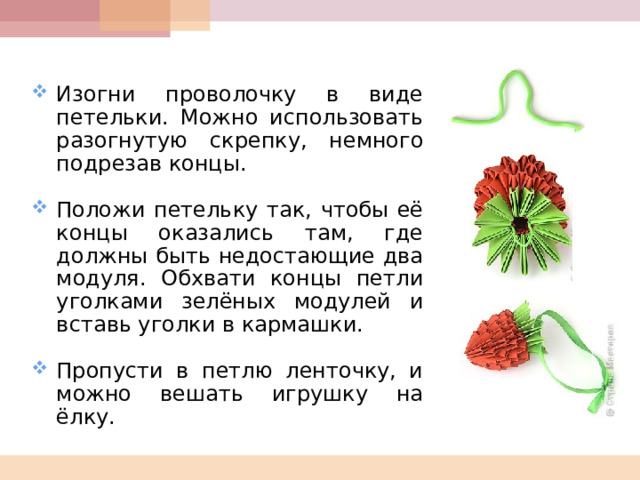  Изогни проволочку в виде петельки. Можно использовать разогнутую скрепку, немного подрезав концы.  Положи петельку так, чтобы её концы оказались там, где должны быть недостающие два модуля. Обхвати концы петли уголками зелёных модулей и вставь уголки в кармашки.  Пропусти в петлю ленточку, и можно вешать игрушку на ёлку.  