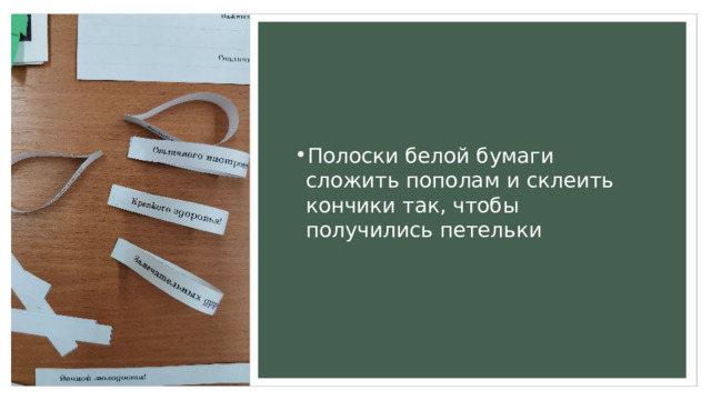 Полоски белой бумаги сложить пополам и склеить кончики так, чтобы получились петельки 
