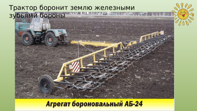 Трактор боронит землю железными зубьями бороны 