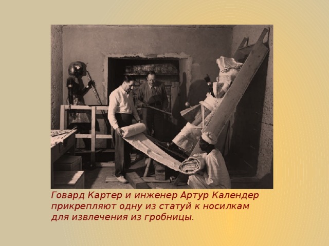 Говард Картер и инженер Артур Календер прикрепляют одну из статуй к носилкам для извлечения из гробницы.   